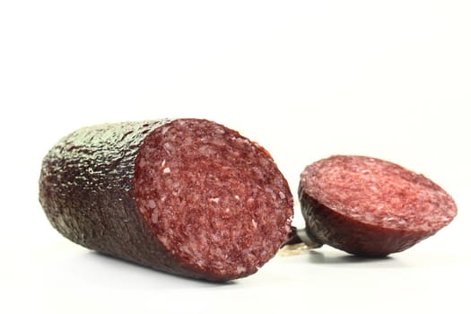 a cut salami in a white background