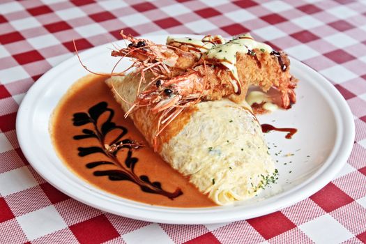 Omurice with king shrimps and sauce on a big plate