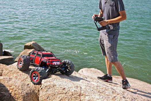 RC toy car on a rugged rock terrain with sea at background