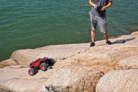 RC toy car on a stone terrain on sea background