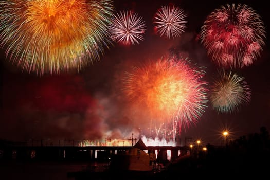 Multiple fireworks on black sky background over the railway bridge