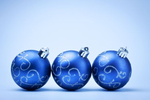 three blue decoration balls on blue background