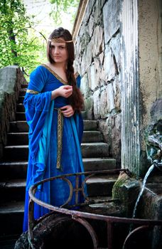 medieval beautiful girl standing next ancient spring