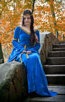 beautiful elf princess sitting on stone staircase