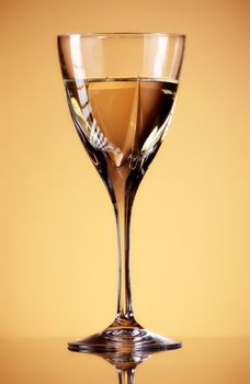 glass of white wine on yellow background