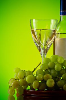 glass of wine and grape bunch, green background