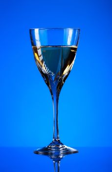 glass of white wine on blue background