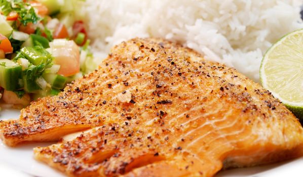 Grilled salmon with rice, on a plate, with salad