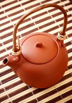 brown clay kettle on striped bamboo napkin