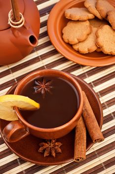 cup of winter tea with cinnamon and star anise on bamboo napkin