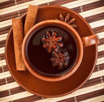 cup of winter tea with cinnamon and star anise on bamboo napkin