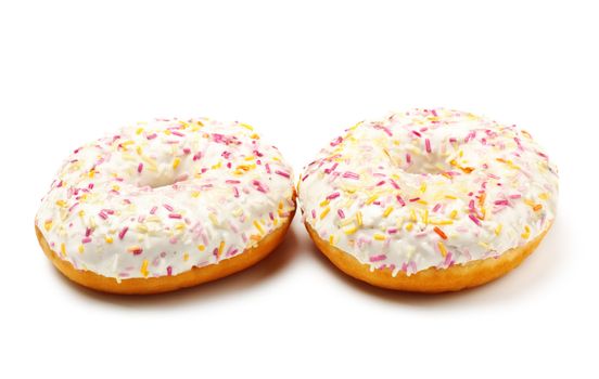 two sugar glazed donuts covered in sprinkles isolated on white