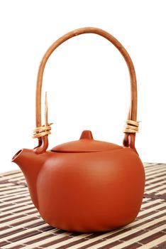 brown clay kettle on striped bamboo napkin