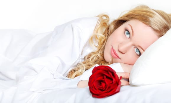 pretty blonde woman in bed with red rose