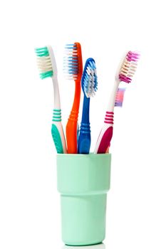 Tooth brushes in glass on a white background
