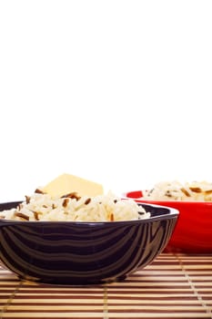 bowls with cooked rice and butter on bamboo napkin