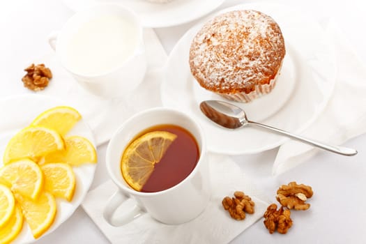 tea with lemon and fancy cakes, still life