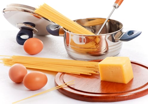 spaghetti, eggs and kitchen utensil on table