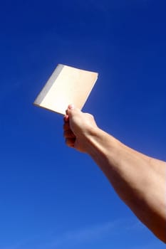 Holding notebook under blue sky