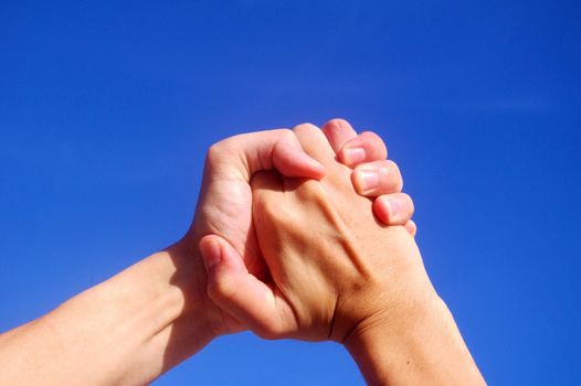Holding hands under blue sky
