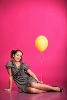 cute girl holding balloons over pink background