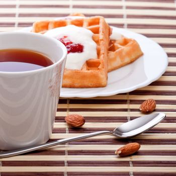 dessert with soft waffle, tea and raspberry jam