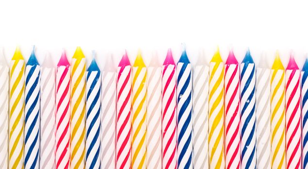 some striped birthday candles on white background