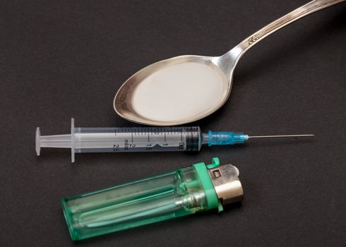 Syringe, spoon, heroin and lighter, concept of addiction