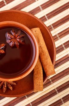 cup of winter tea with cinnamon and star anise on bamboo napkin