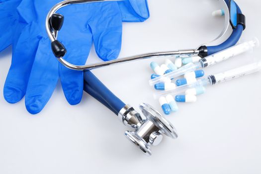 Syringe tablets and other medical items on white background
