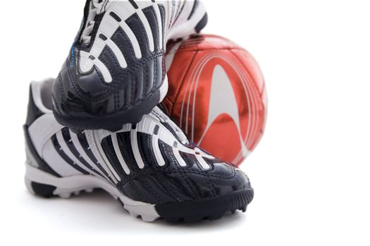 Sports footwear and red soccer ball on a white background