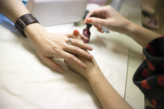 manicure treatment of female hands in beauty salon