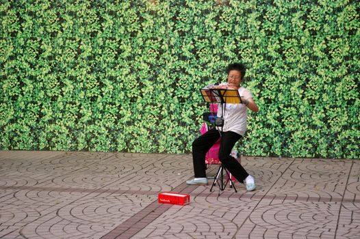 HONG KONG - AUG 22, A woman is singing along the street to earn money in Hong Kong on 22 August, 2010.