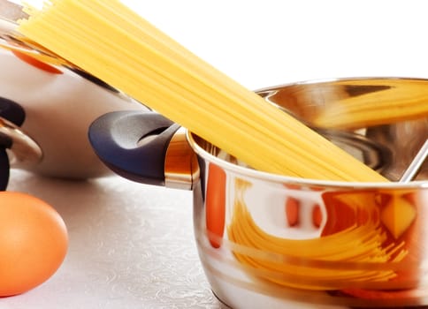 raw spaghetti in casserole on white table