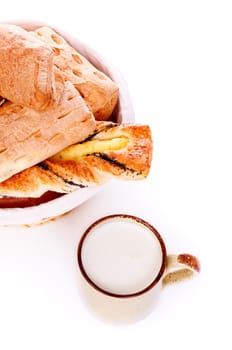 basket with buns and mug of milk on white