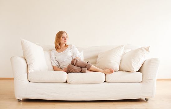 cute young girl relaxing on couch at home