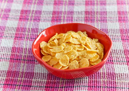 cornflakes with milk in bowl on napkin