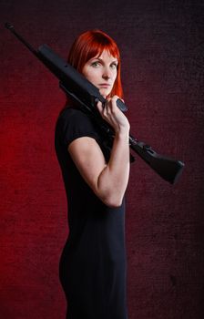 woman in black dress with sniper rifle, red background