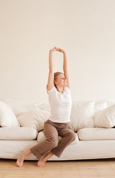 cute young girl relaxing and stretches on couch at home