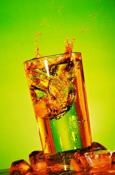 glass with splashing soda on yellow background