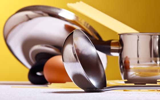 spaghetti, eggs, cheese and utensils on table