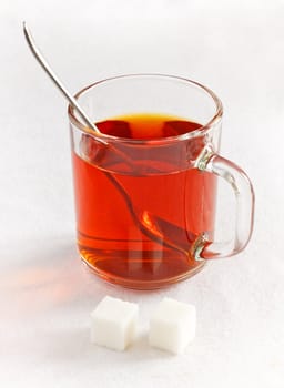 tea in glass with sugar cubes on table