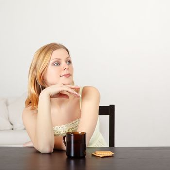 beautiful woman sitting at table drinking tea