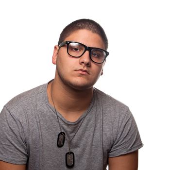 A young teenage man isolated over white wearing black frame nerd type vintage glasses and military style dog tags.