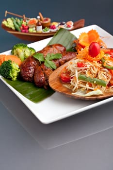 Plate of freshly prepared Thai sausage and som tum green papaya salad.