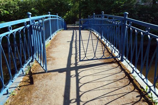 Opened gate on the narrow bridge over small river