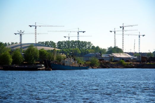 Lot of cranes construction over the blue river