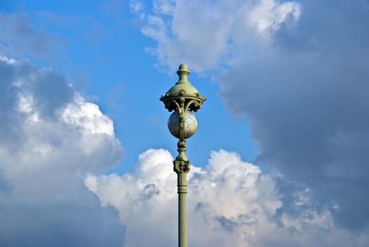 vintage street lamp with glass sphere on cloud sky background