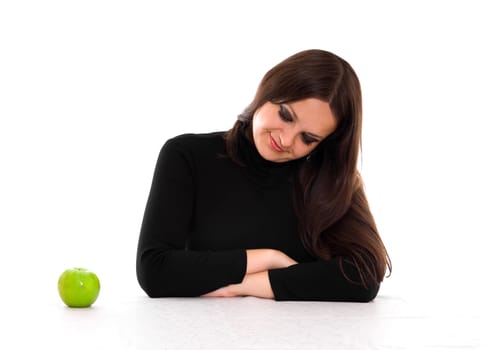 young woman with long brown hair staring at the green apple