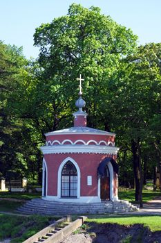Small chapel standing in the middle of summer park
